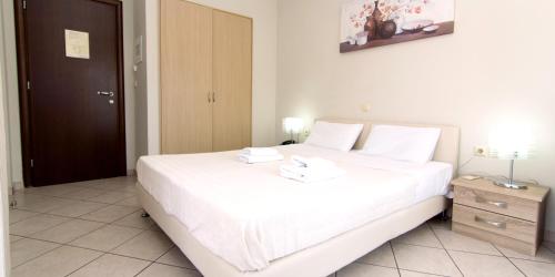 a bedroom with a large white bed with two towels on it at San Nectarios in Parga