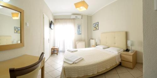 a bedroom with a bed and a table and a mirror at San Nectarios in Parga