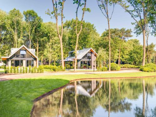 una casa con un estanque delante de ella en TopParken – Landgoed de Scheleberg, en Lunteren