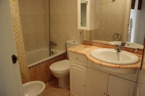 a bathroom with a sink and a toilet and a tub at Apartamento Cascadas - Deniasol in Denia