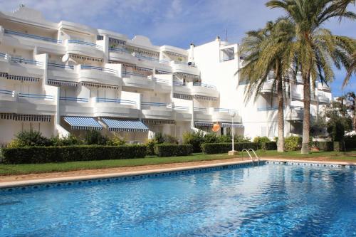 un hotel con piscina di fronte a un edificio di Apartamento Las Barcas - Deniasol a Denia