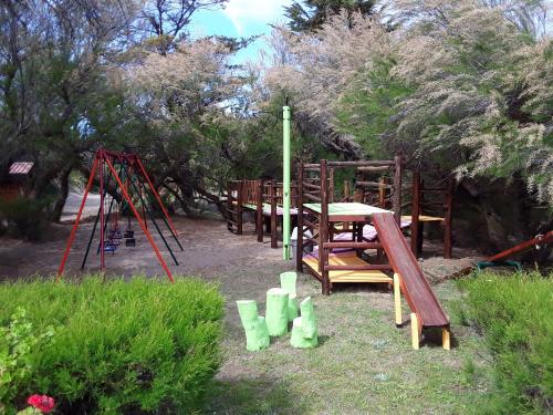 un parque infantil con mesa y columpio en Ymcamar en Monte Hermoso