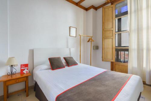 1 dormitorio con 1 cama con 2 almohadas en Hostal Austria, en Granada