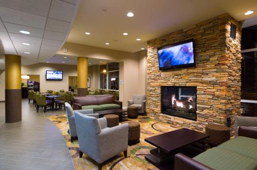 a lobby with a fireplace with a tv on a stone wall at Holiday Inn Express Philadelphia Penn's Landing by IHG in Philadelphia