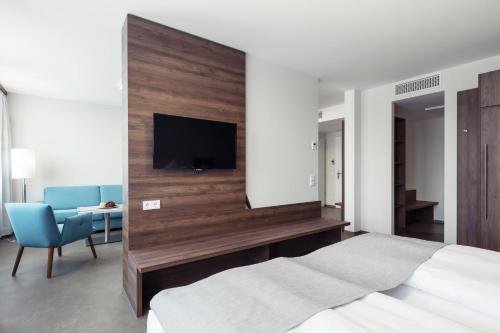 a bedroom with two beds and a flat screen tv at Apart-Hotel FirstBoarding Bayreuth in Bayreuth