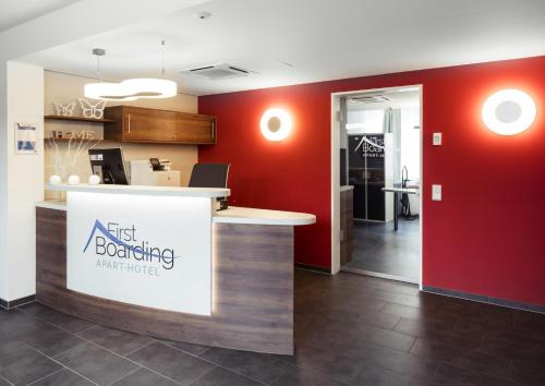 an office with a firstboarding counter and red walls at Apart-Hotel FirstBoarding Bayreuth in Bayreuth