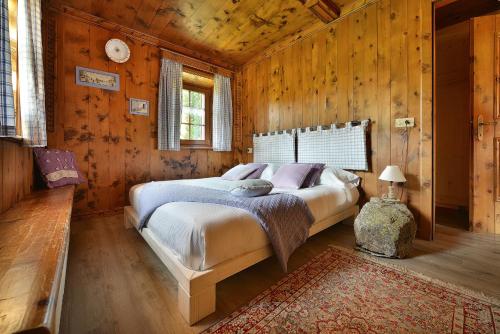 um quarto com uma cama num quarto com paredes de madeira em La Dormeuse em Livigno