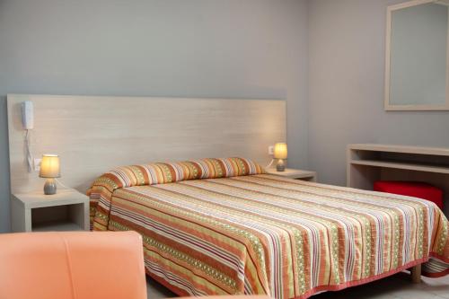 a bedroom with a bed with a colorful blanket at Hotel Arcu Di Sole in Propriano