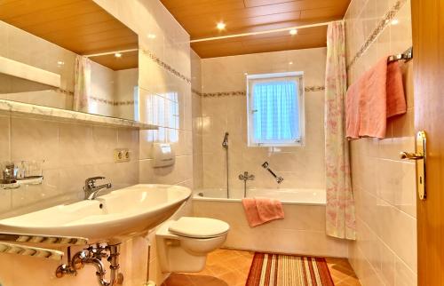 ein Badezimmer mit einem Waschbecken, einem WC und einer Badewanne in der Unterkunft Alpenland Schneck in Berchtesgaden