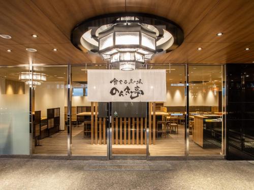 a restaurant with glass doors and a sign on the wall at APA Hotel Kyoto Ekihigashi in Kyoto