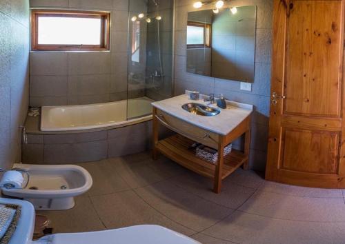 La salle de bains est pourvue d'un lavabo, d'une baignoire et de toilettes. dans l'établissement Casa Roma, à Villa La Angostura