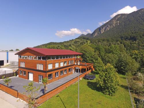 a large wooden house with a red roof at Paradies in den Bergen nahe Garmisch Partenkirchen in Eschenlohe