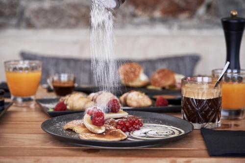 een tafel met borden met eten en drinken bij Mykonos Bliss - Cozy Suites, Adults Only Hotel in Kalo Livadi