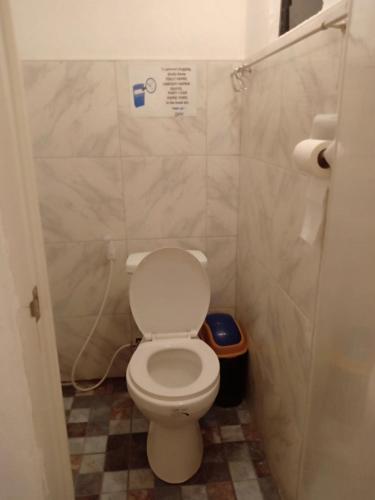 a bathroom with a white toilet in a stall at LightHaus DP Garden Resort in Siquijor