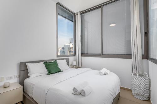 1 dormitorio con cama y ventana grande en Ben Gurion Area - Modern 2 BDR with balcony, en Tel Aviv