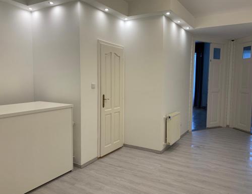 an empty room with a white wall and a door at W19 Apartments in Miskolc