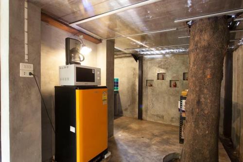 a room with a microwave on top of a refrigerator at Chiang Mai Summer Resort in Chiang Mai