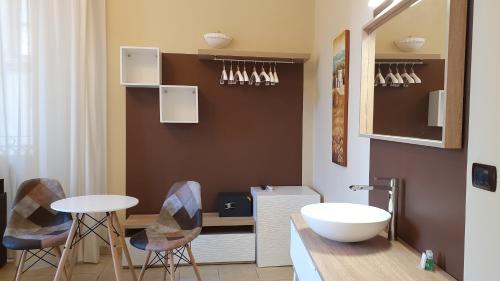 a bathroom with a sink and a table and chairs at B&B Diana in Siracusa