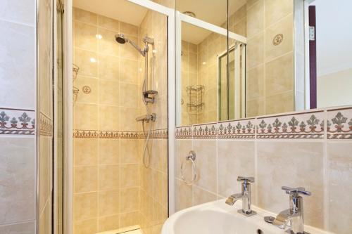 a bathroom with a shower and a sink and a mirror at Burbage Holiday Lodge Apartment 4 in Blackpool