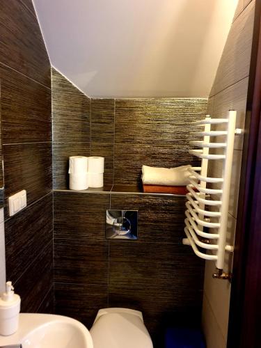 a bathroom with a toilet and towels on a wall at Pokoje Felix in Słupsk