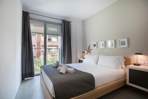 a bedroom with a bed and a large window at BBarcelona Gaudí Flats in Barcelona