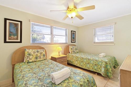 a bedroom with two beds and a ceiling fan at Playa Casanas North in Holmes Beach