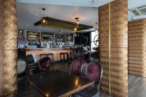 ブライトン＆ホーブにあるAmsterdam Hotel Brighton Seafrontの木製テーブルと椅子付きのバー