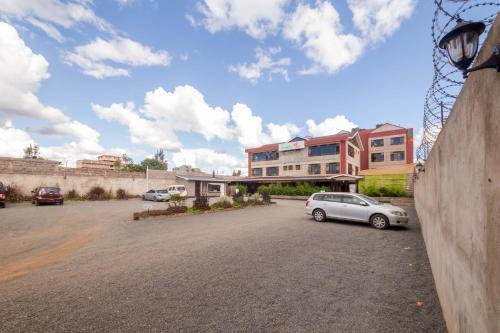 a car parked in a parking lot next to a building at Maple Inn Hotel in Nairobi