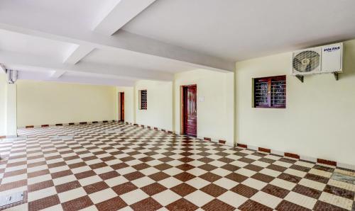 an empty room with a checkered floor at Umaiyyal Home Stay in Kanyakumari