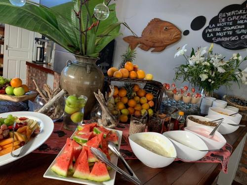 a table topped with plates of fruit and a vase at Cape St Francis Resort in Cape St Francis