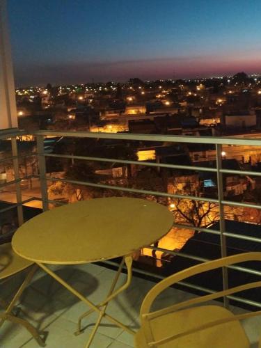 a table and chairs on a balcony with a view of a city at Departamento Parque Alem in Rosario