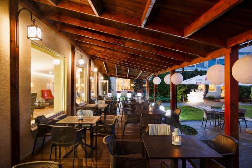 a restaurant with wooden tables and chairs and lights at Falenty Biznes i Wypoczynek in Raszyn