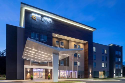 a building with a sun sign on the side of it at La Quinta by Wyndham Greensboro Airport High Point in Greensboro
