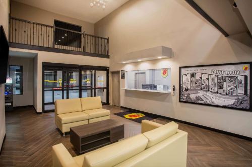 a living room with a couch and chairs and a table at Super 8 by Wyndham St. Louis North in Saint Louis