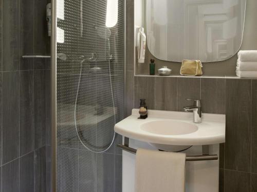 W łazience znajduje się umywalka oraz prysznic z lustrem. w obiekcie ibis Velizy Jouy-En-Josas w mieście Jouy-en-Josas
