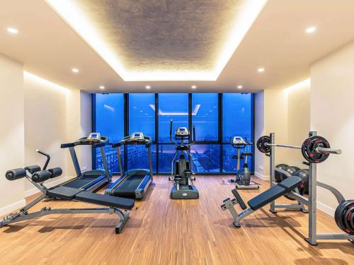 a gym with cardio equipment and a large window at Mercure Almaty City Center in Almaty