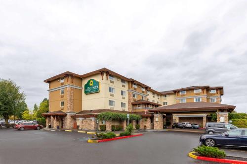 a hotel with cars parked in a parking lot at La Quinta by Wyndham Vancouver in Vancouver