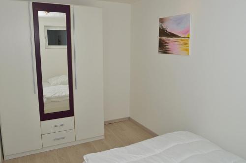Habitación blanca con espejo y cama en Apartment in Reutlingen / Sickenhausen, en Reutlingen