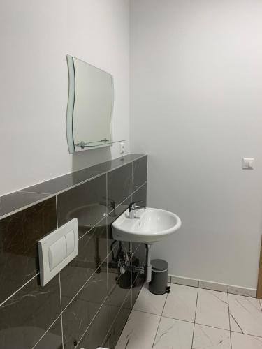 a bathroom with a sink and a mirror on the wall at Luxury Private Apartment in Horná Potôň