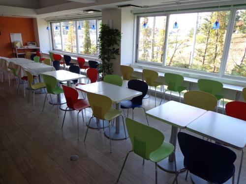 a room with tables and chairs and windows at Smile Hotel Sendai Izumi IC in Sendai