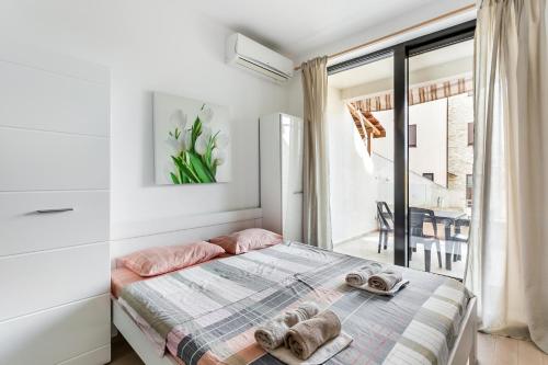 a bedroom with a bed with slippers on it at Apartments BEATRICE Rafailovici in Rafailovici