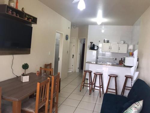 a kitchen and dining room with a table and chairs at Lindo Apto. Frente Praia (Cond. Dom Felippe) in São Lourenço do Sul