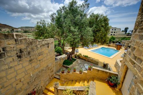 an external view of a villa with a swimming pool at Razzett Ghasri in Għasri