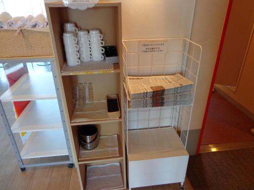 a cupboard with shelves and boxes in a room at Smile Hotel Sendai Izumi IC in Sendai