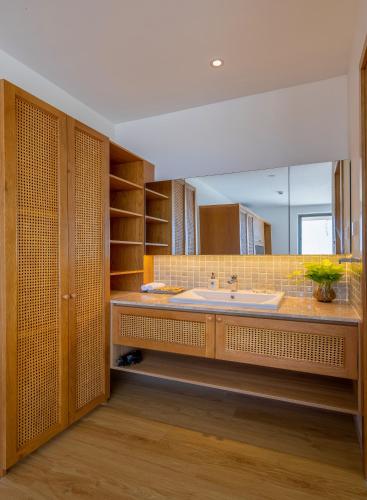 a bathroom with a large sink and a large mirror at Prana Boutique Hotel and Apartments in Danang