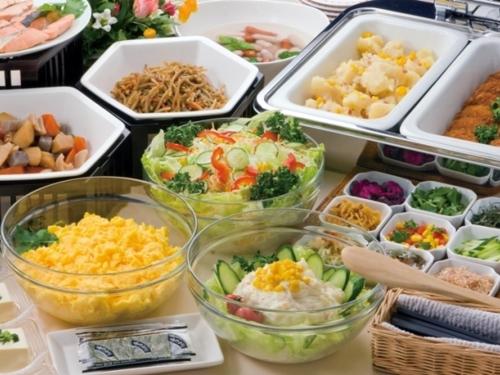 a table topped with bowls of different types of food at Smile Hotel Sendai Izumi IC in Sendai