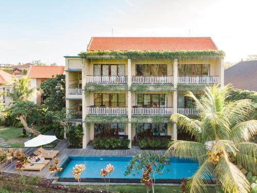 um hotel com piscina em frente a um edifício em Byasa Ubud em Ubud