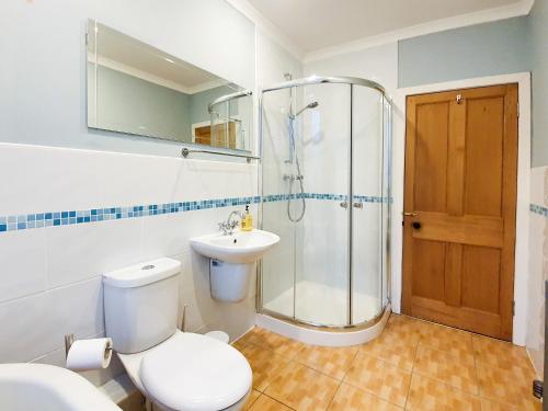 a bathroom with a toilet and a shower and a sink at Linburn House Apartment in Dunfermline