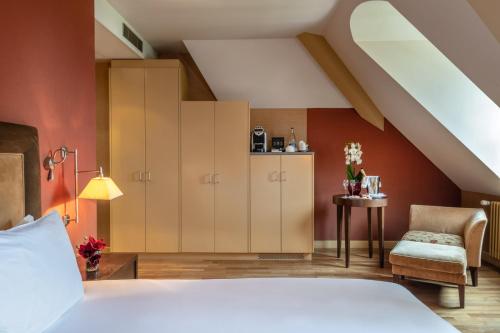a bedroom with a bed and a table and a chair at Hôtel Résidence Parc des Eaux Vives in Geneva