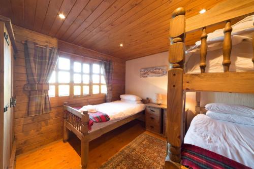 a bedroom with two bunk beds in a cabin at Walnut Log Cabin in Swanage